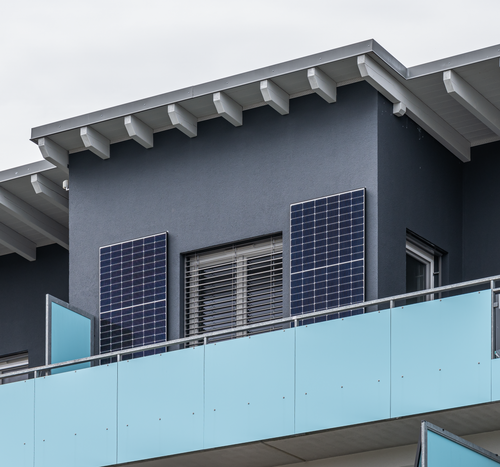 Two upright solar panels behind a balcony railing in Hof.